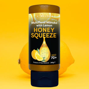 Melora Manuka Honung 70+ MGO Lemon Squeeze 330 g – Honey Squeeze Lemon mot gul bakgrund